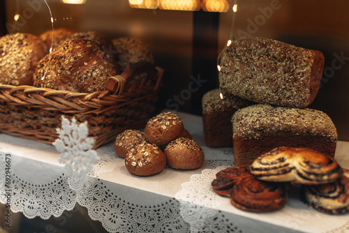 Fototapeta Naklejka Na Ścianę i Meble -  Soft multigrain bread and sweet buns in a wicker basket in a fresh baked goods store