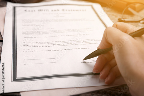 Woman signing Last Will and Testament at table, closeup photo