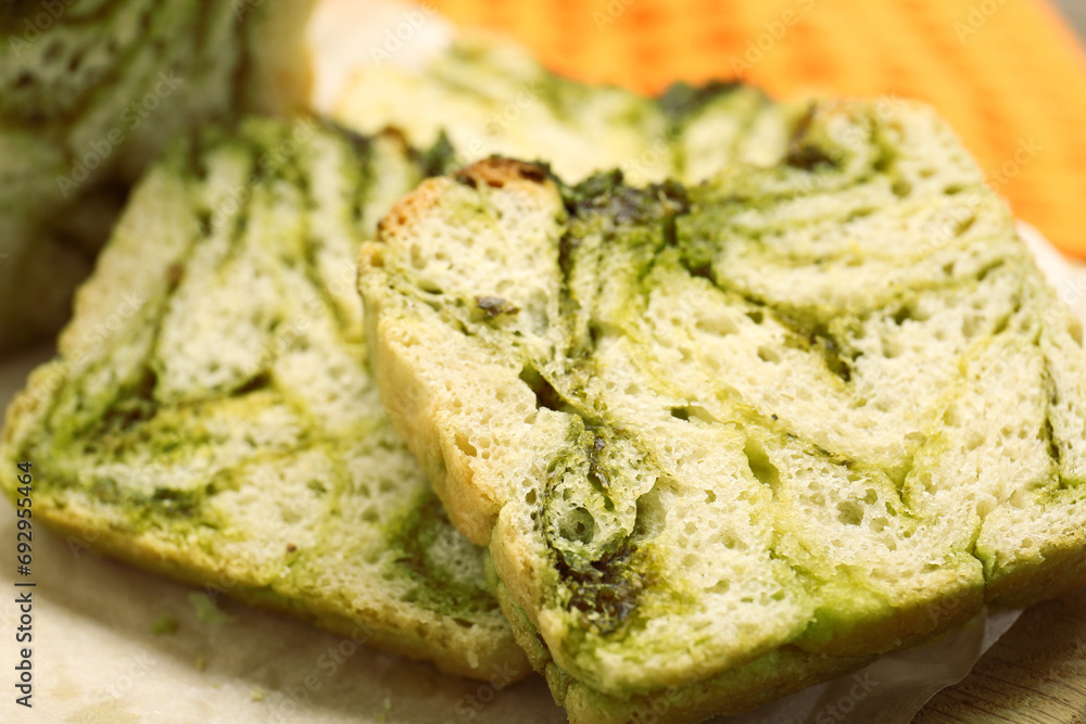 Slices of freshly baked pesto bread on wooden board, closeup Slices of freshly baked pesto bread on wooden board, closeup