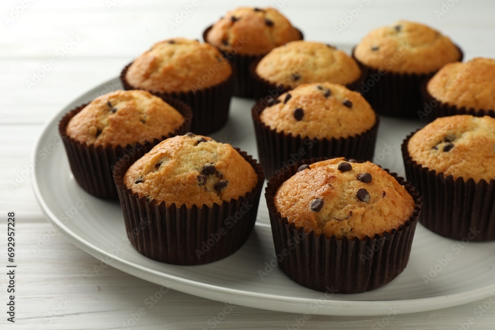 Delicious freshly baked muffins with chocolate chips on table, closeup Delicious freshly baked muffins with chocolate chips on table, closeup