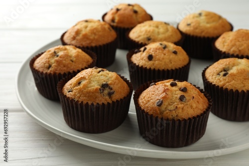 Delicious freshly baked muffins with chocolate chips on table, closeup