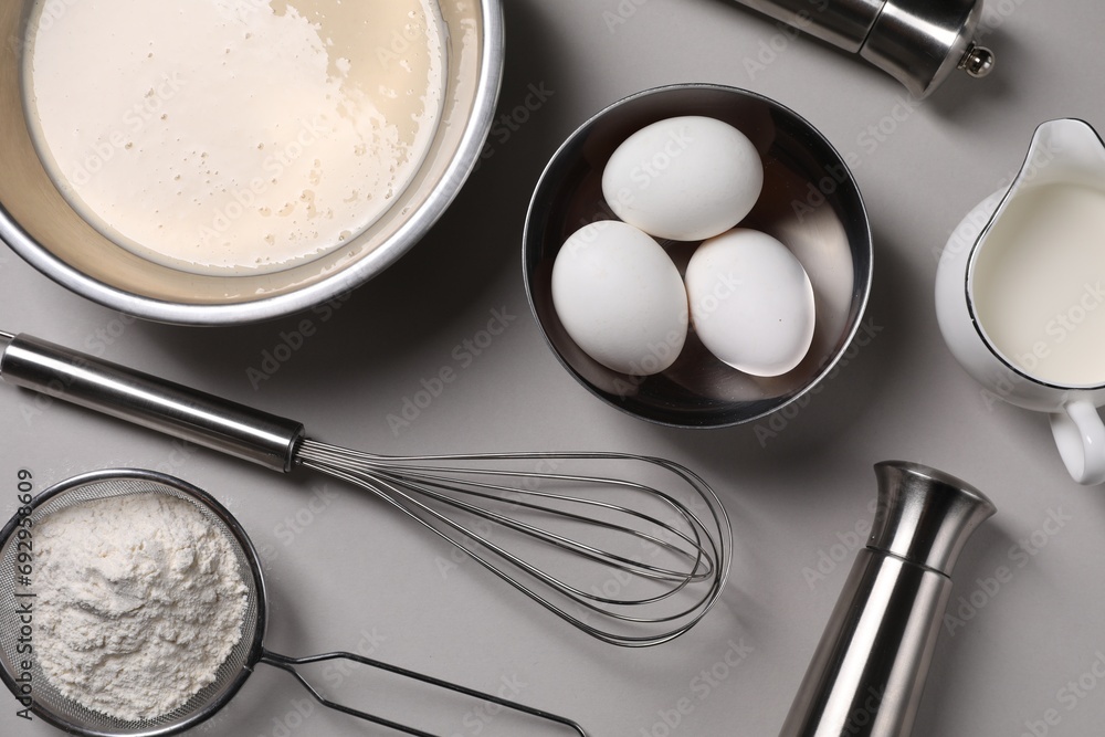 Flat lay composition with dough in bowl and metal whisk on grey background Flat lay composition with dough in bowl and metal whisk on grey background