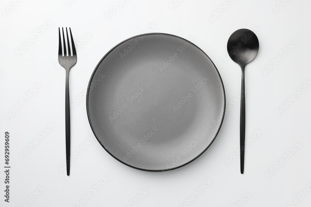 Empty plate, fork and spoon on white background, top view Empty plate, fork and spoon on white background, top view