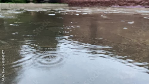 It's raining lightly, puddles in the street.