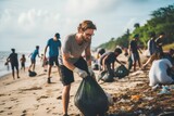 A young man actively picking up trash along with a group of dedicated volunteers on the beach, highlighting collective efforts in environmental conservation.