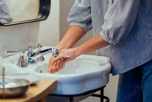Caucasian woman washes her hands. Close-up of girl washing her hands in bathroom.