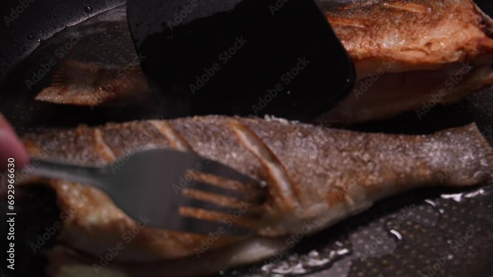 Fish is turned when pan frying. Close-up. Fish is turned when pan frying. Close-up.