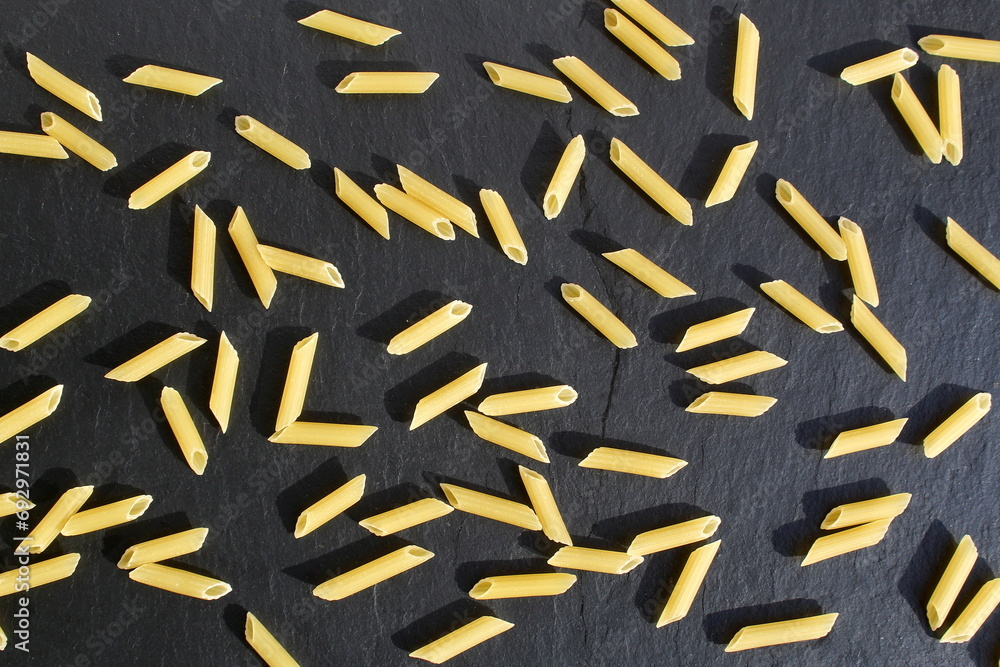 Background of pasta lying on a black stone background. Background of pasta lying on a black stone background.