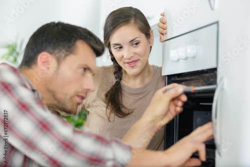 couple checking a broken oven