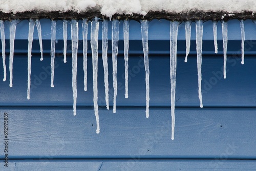 Eiszapfen vor blauem Holzhintergrund