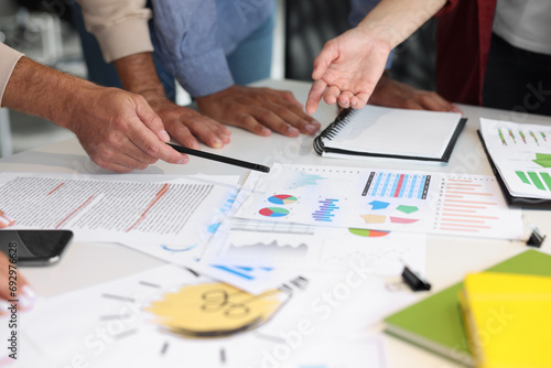 Team of employees working with charts at table, closeup. Startup project