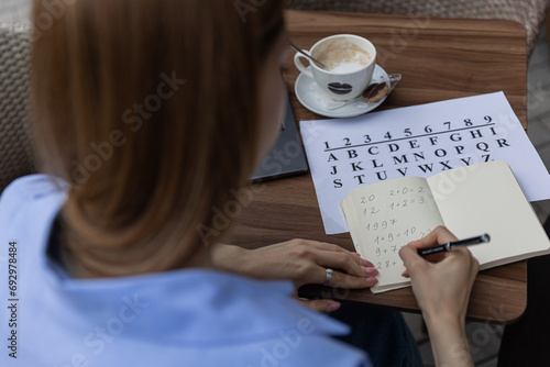 numerologist girl makes a calculation according to numerology, future by date of birth, find out her purpose with the help of numbers top view