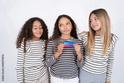 Photo of cheerful multi racial group of girl friends hold debit card look empty space