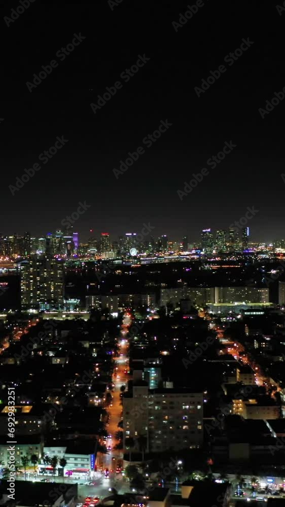 Illuminated Urban Skyline of Miami Beach and Miami Downtown at Night. Aerial View. USA. Drone Flies Sideways. Vertical Video Illuminated Urban Skyline of Miami Beach and Miami Downtown at Night. Aerial View. USA. Drone Flies Sideways. Vertical Video