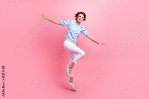 Full body photo of overjoyed gorgeous lady jumping arms wings flying isolated on pink color background