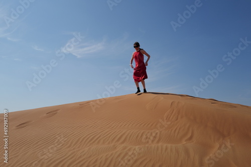 Woman in red dress on sand dunes