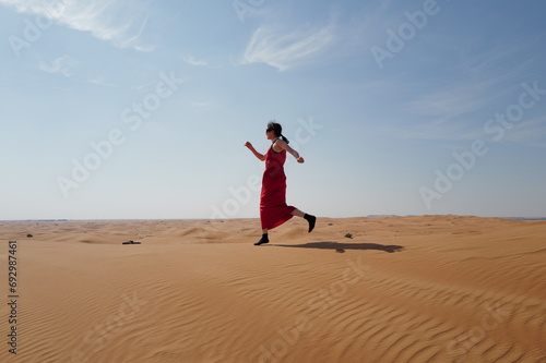 Woman in red dress on sand dunes