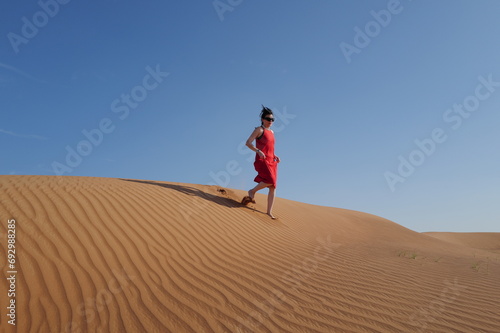 Woman in red dress on sand dunes