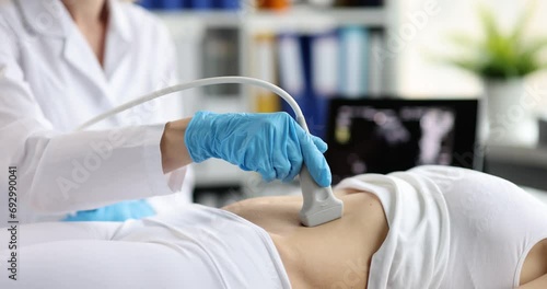 The doctor makes an ultrasound of the abdominal cavity, close-up. Diagnostics of the pelvic organs, medical equipment photo