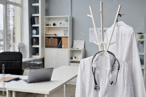 Εκτύπωση καμβά Medium close up of lab coats and stethoscope in doctors office, working desk and