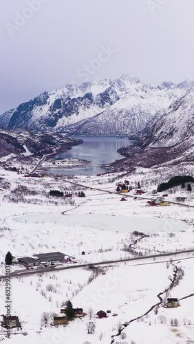 Mountains in Winter. Lofoten Islands, Landscape of Norway. Aerial View. Drone Flies Forward, Tilt Up. Reveal Shot . Vertical Video photo