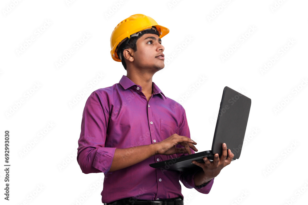 Handsome Indian man wearing yellow hardhat looking up posing with laptop in studio. Handsome Indian man wearing yellow hardhat looking up posing with laptop in studio.