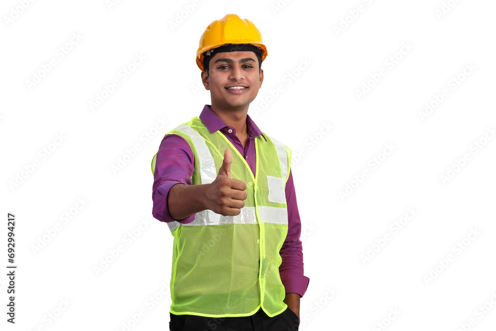 Indian male architect wearing yellow helmet and safety jacket showing thumbs up in studio. Indian male architect wearing yellow helmet and safety jacket showing thumbs up in studio.
