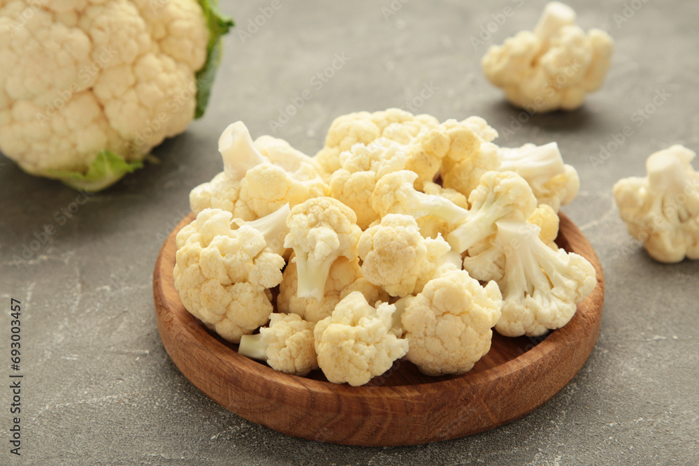 Wooden bowl of cauliflower on grey background Wooden bowl of cauliflower on grey background