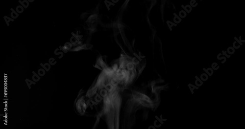 White steam from hot food or drink. White steam on a black background rises to the top. Cooking a hot meal in the kitchen.