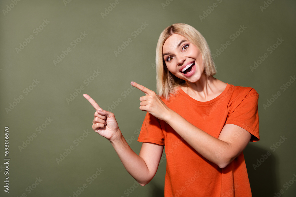 Photo portrait of attractive young woman point empty space impressed dressed stylish orange clothes isolated on khaki color background Photo portrait of attractive young woman point empty space impressed dressed stylish orange clothes isolated on khaki color background