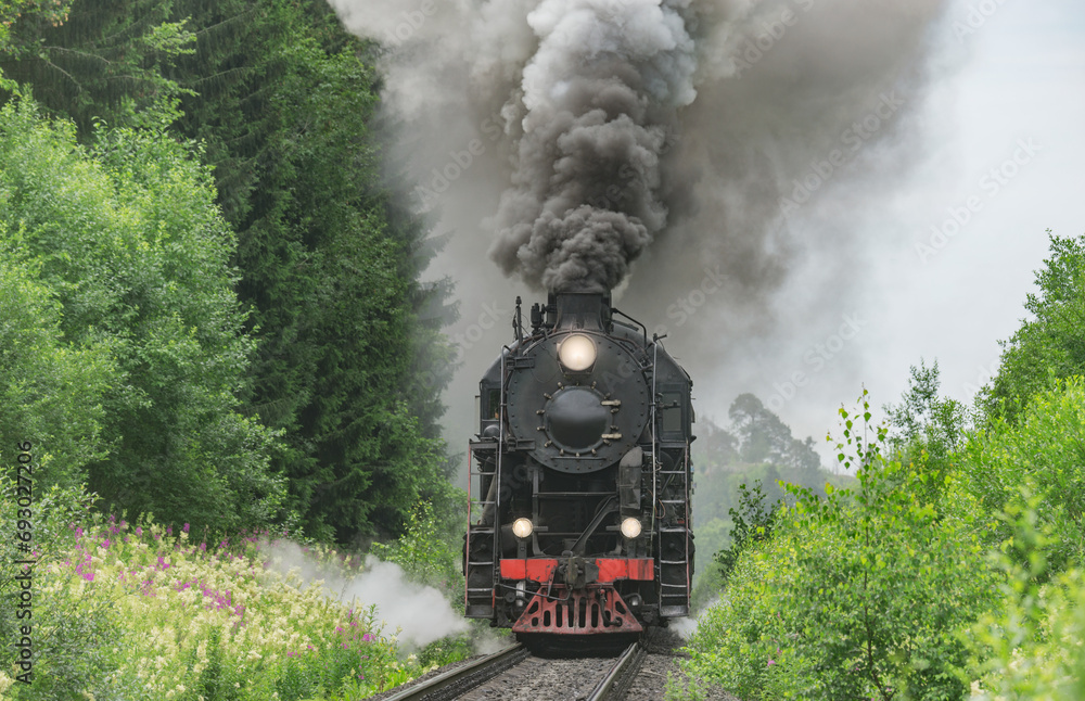 Obraz premium Retro steam train approaches to the platform.