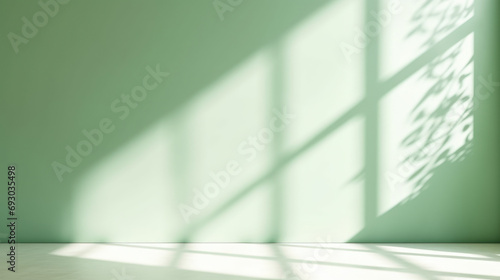 Minimal abstract light green background for product presentation. Shadow and light from windows on plaster wall.