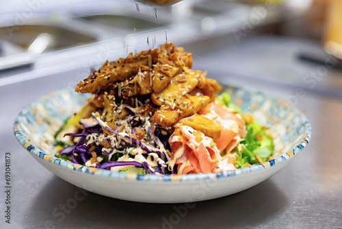 Stockholm, Sweden A Poke Bowl in a restaurant with red cabbage, beans, mango and dressing, and salmon and chicken breast. photo