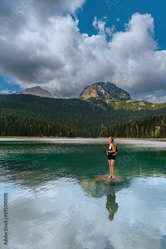 Woman Solo Traveler Standing in Black Lake