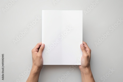 A professional presentation with hands holding a blank sheet of paper on a white background. photo