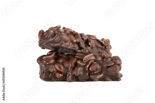 Two bars of sweet brownies with nuts and covered with chocolate on a white background.