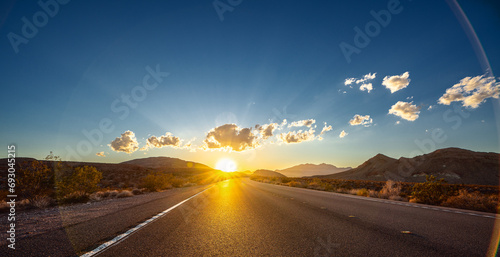 Empty long nevada mountain road to the horizon on a sunny summer day at bright sunset photo