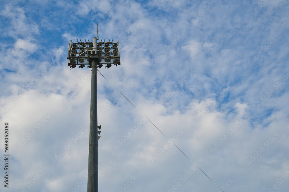 Stadium floodlight against blue sky.
