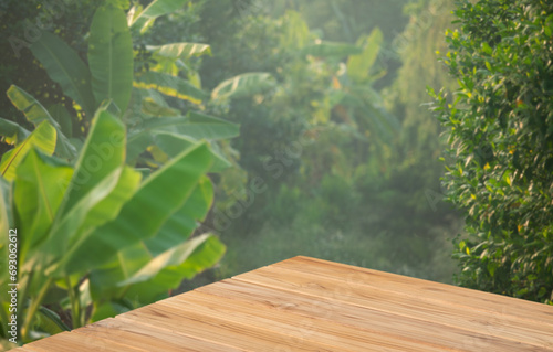 Wood tabletop floor in outdoors blur green leaf tropical forest nature background.cosmetic natural product mock up placement pedestal stand display jungle summer concept.