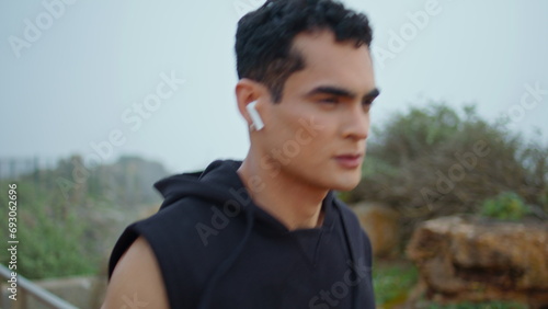 Motivated runner jogging morning closeup. Focused handsome man training outdoors