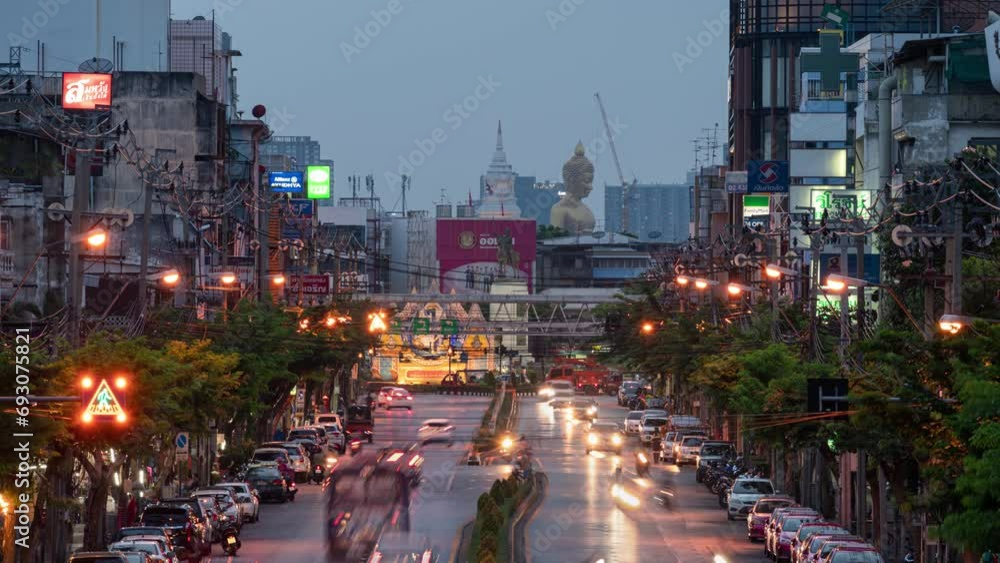 Cityscape of buildings with traffic on the road and golden large buddha in downtown at night Cityscape of buildings with traffic on the road and golden large buddha in downtown at night