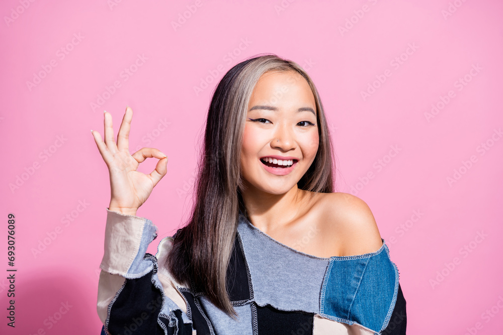 Portrait of cheerful charming girl toothy smile hand fingers demonstrate okey symbol isolated on pink color background Portrait of cheerful charming girl toothy smile hand fingers demonstrate okey symbol isolated on pink color background
