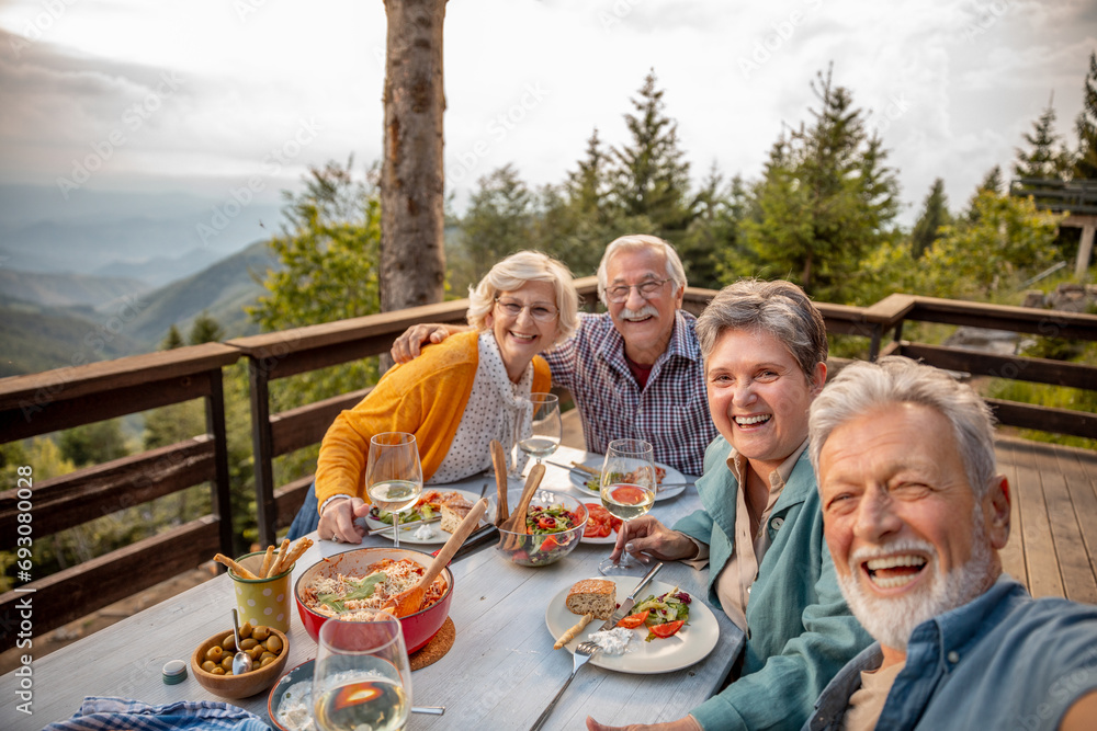 Happy senior people taking selfie on mountain cabin deck Happy senior people taking selfie on mountain cabin deck