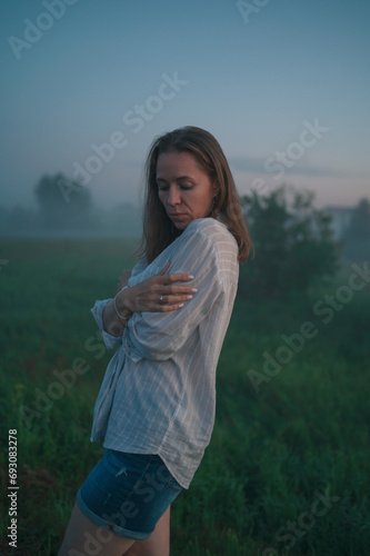 Woman in a field with misty...