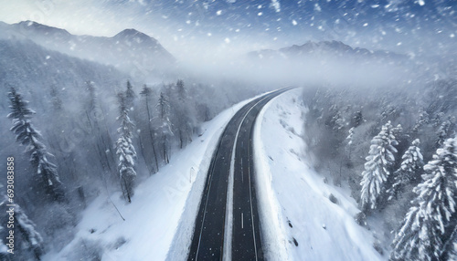 Aerial view of snow-covered highway in the mountains.