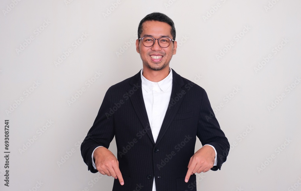 Fototapeta premium Asian businessman smiling confident with both hands pointing below