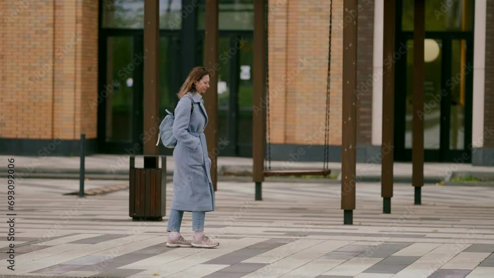 full-length portrait of middle-aged woman walking alone in city street in autumn day, walk in city full-length portrait of middle-aged woman walking alone in city street in autumn day, walk in city