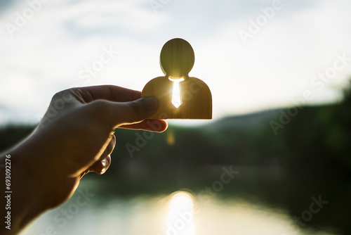 Hand holding icon of a businessman with a mountain view on the background, concept of vision, attitude about success, ,opportunities, future business trends and work life balance.	 photo