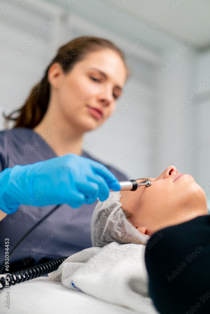 Fototapeta premium a beautician doctor massaging the skin of a client's face during a beauty and health cosmetic procedure