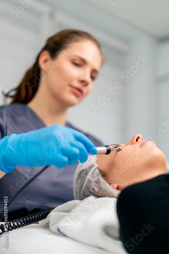 a beautician doctor massaging the skin of a client's face during a beauty and health cosmetic procedure